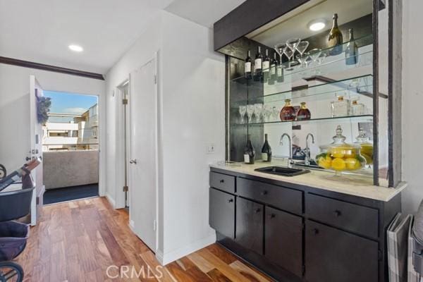 bar featuring hardwood / wood-style floors and sink