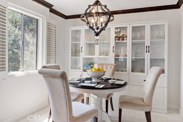 dining room with crown molding and a chandelier