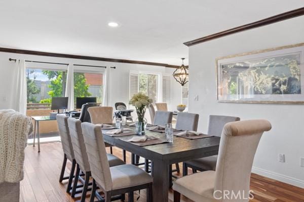 dining room with hardwood / wood-style flooring, plenty of natural light, and crown molding