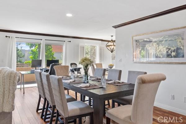 dining room with light hardwood / wood-style flooring, a healthy amount of sunlight, and crown molding