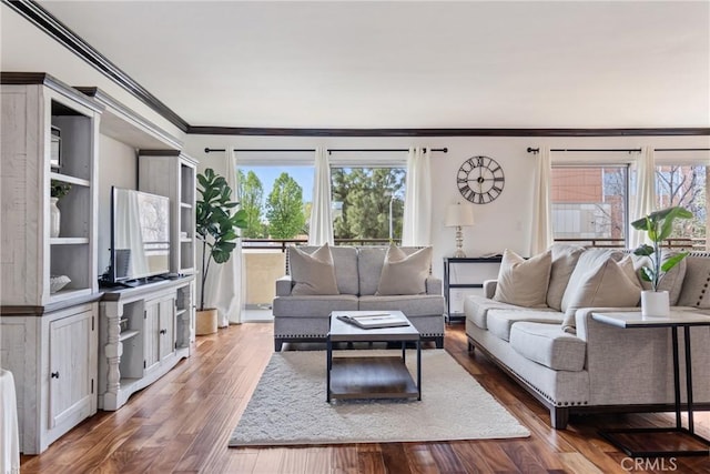 living area with a healthy amount of sunlight, crown molding, and wood finished floors