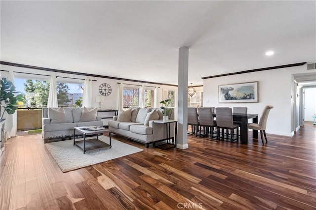 living area with a notable chandelier, dark wood-style flooring, visible vents, baseboards, and crown molding