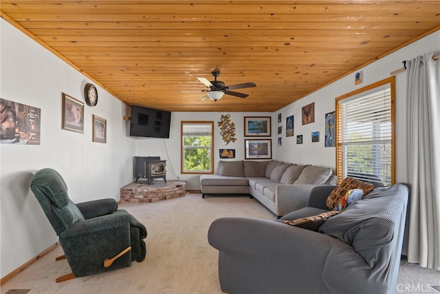 carpeted living room featuring wooden ceiling, ceiling fan, and a wood stove