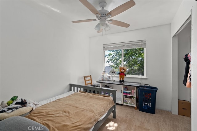 bedroom with light colored carpet, ceiling fan, and a closet