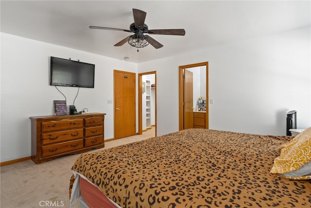 bedroom with a closet, ceiling fan, a spacious closet, and light carpet