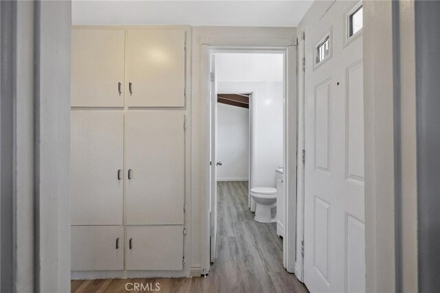 hallway with light hardwood / wood-style floors