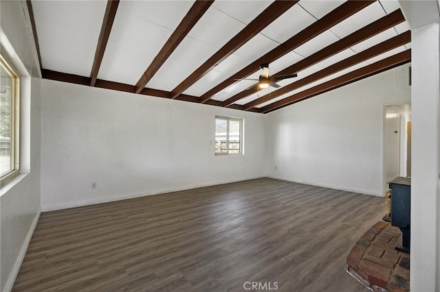 unfurnished living room featuring a wood stove, ceiling fan, dark hardwood / wood-style flooring, and lofted ceiling with beams