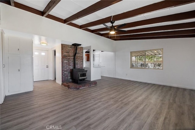 unfurnished living room with hardwood / wood-style floors, ceiling fan, vaulted ceiling with beams, and a wood stove