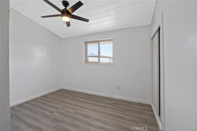 empty room with ceiling fan and light hardwood / wood-style flooring