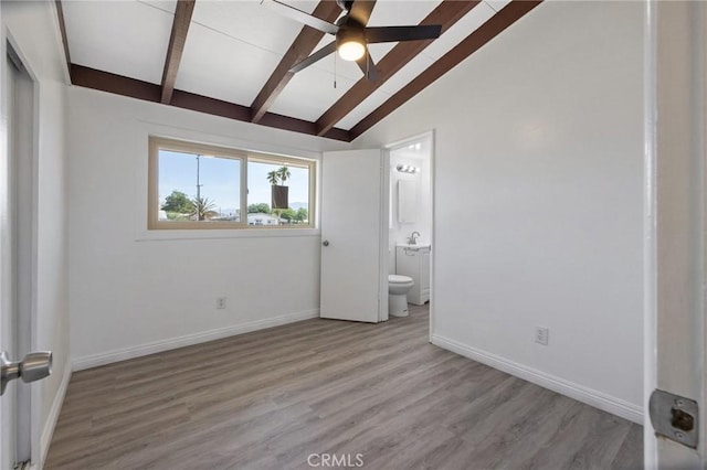 unfurnished bedroom with vaulted ceiling with beams, ceiling fan, light wood-type flooring, and connected bathroom