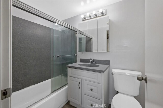 full bathroom featuring vanity, toilet, and enclosed tub / shower combo