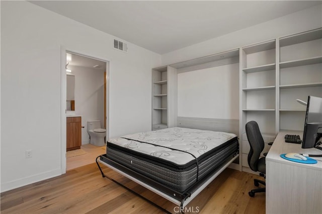 bedroom featuring light hardwood / wood-style floors and ensuite bathroom