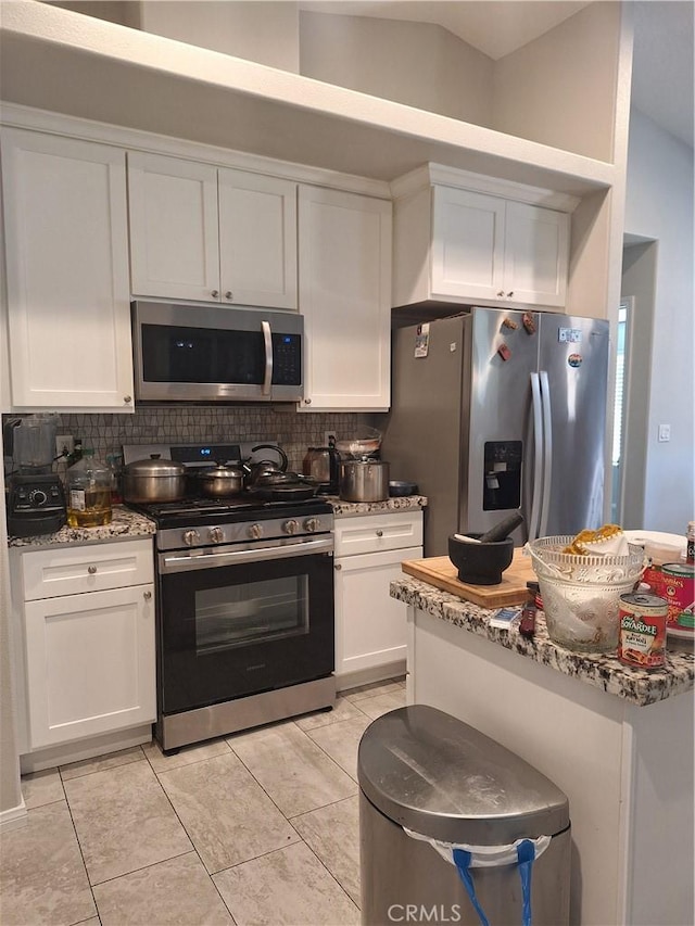 kitchen featuring decorative backsplash, appliances with stainless steel finishes, stone countertops, and white cabinets