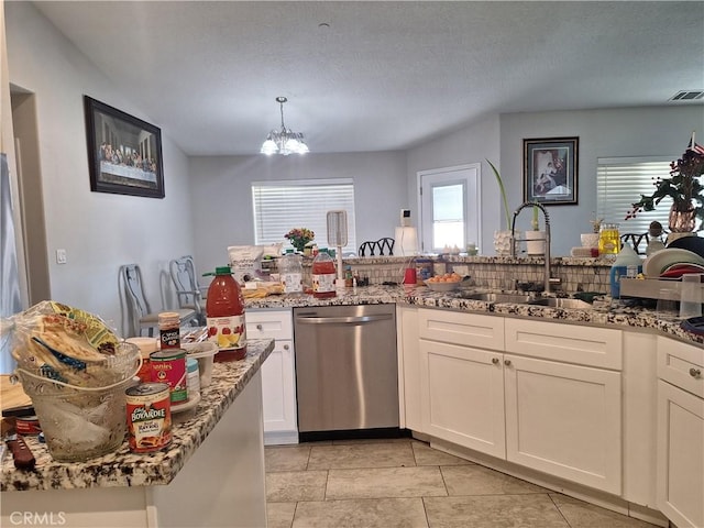 kitchen with white cabinets, sink, stainless steel dishwasher, light stone countertops, and a notable chandelier