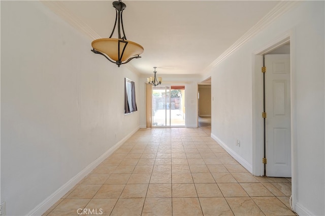 tiled empty room featuring ornamental molding and a chandelier