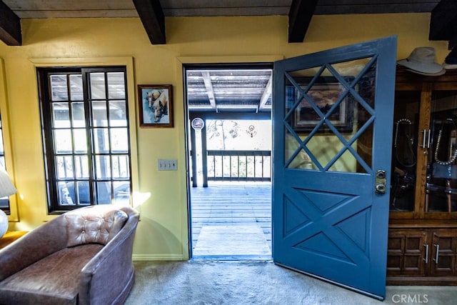 entryway with beamed ceiling and carpet floors