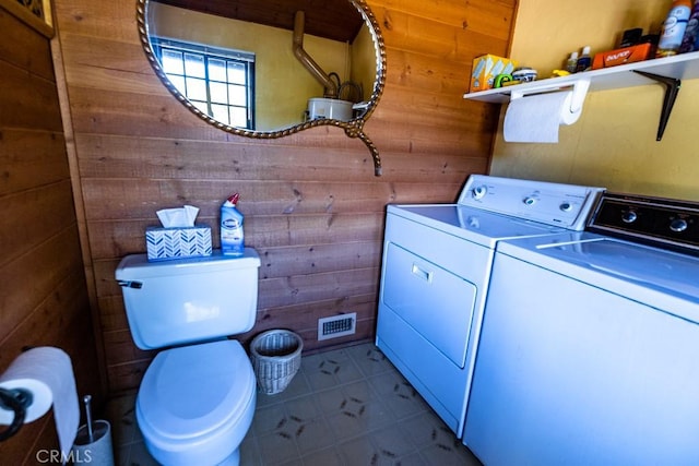 laundry room featuring independent washer and dryer and wooden walls