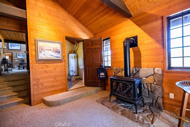 interior space featuring wood ceiling, water heater, wooden walls, and a healthy amount of sunlight