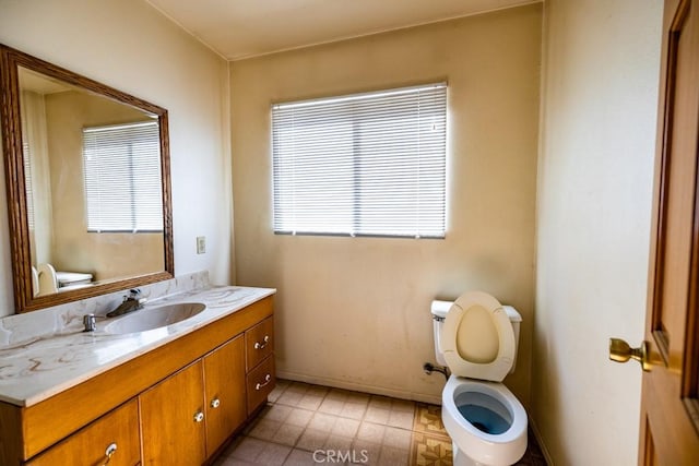 bathroom with a wealth of natural light, vanity, and toilet