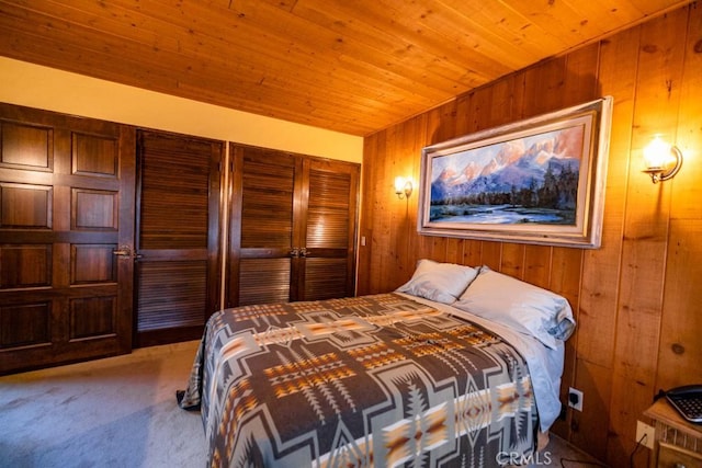 carpeted bedroom featuring wood walls, wooden ceiling, and a closet