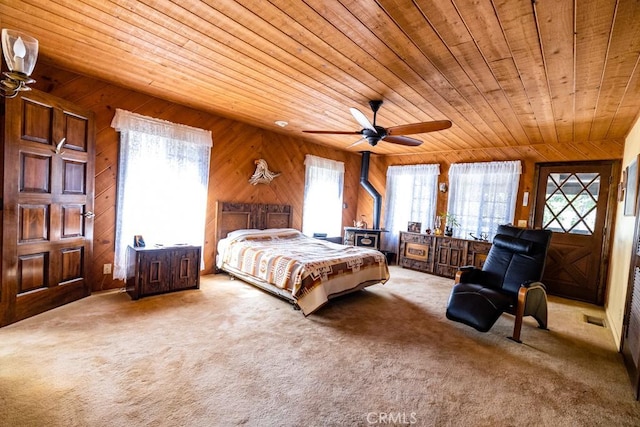 bedroom featuring carpet, ceiling fan, wooden ceiling, and wooden walls