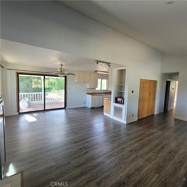 unfurnished living room featuring high vaulted ceiling, ceiling fan, and dark wood-type flooring