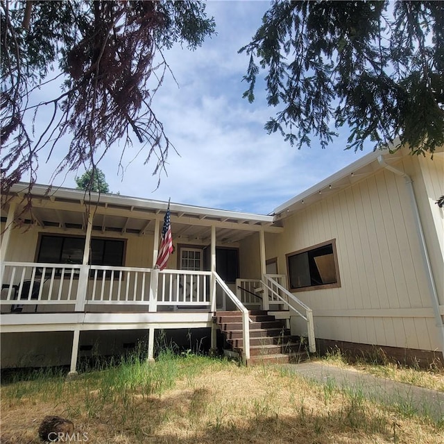 rear view of property featuring covered porch