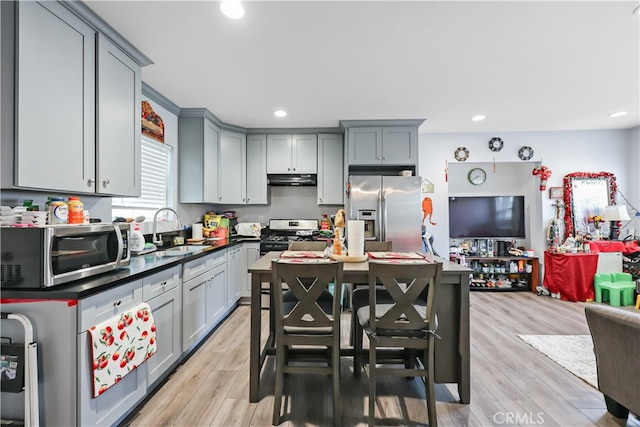 kitchen featuring stainless steel appliances, sink, light wood-type flooring, and gray cabinets