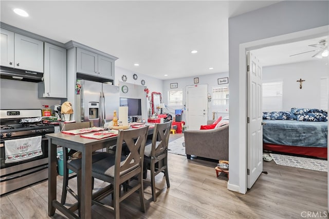 kitchen featuring stainless steel appliances, gray cabinetry, ceiling fan, and light wood-type flooring