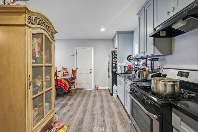 kitchen featuring appliances with stainless steel finishes, gray cabinets, and light wood-type flooring