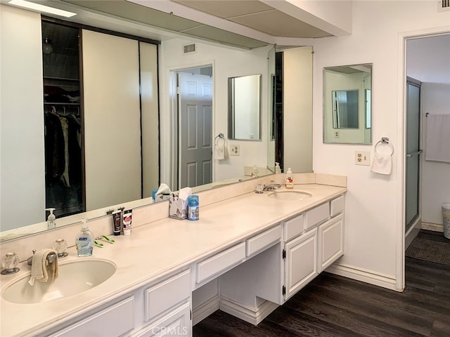 bathroom featuring walk in shower, vanity, and hardwood / wood-style flooring