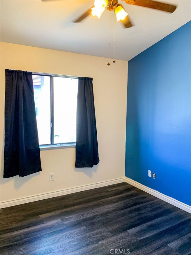 empty room featuring ceiling fan and dark wood-type flooring