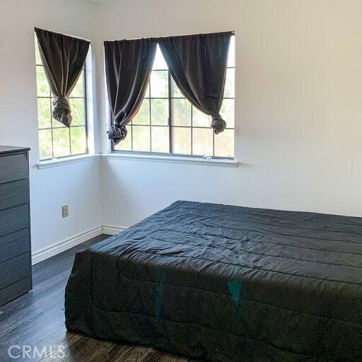 bedroom with dark wood-type flooring