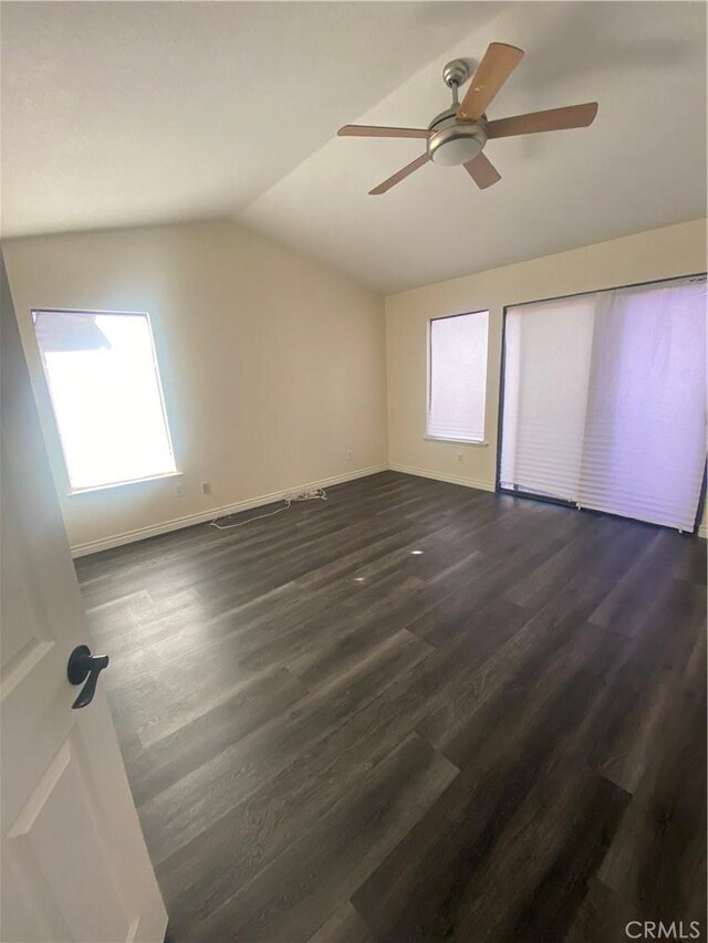 interior space with multiple windows, ceiling fan, and dark hardwood / wood-style floors