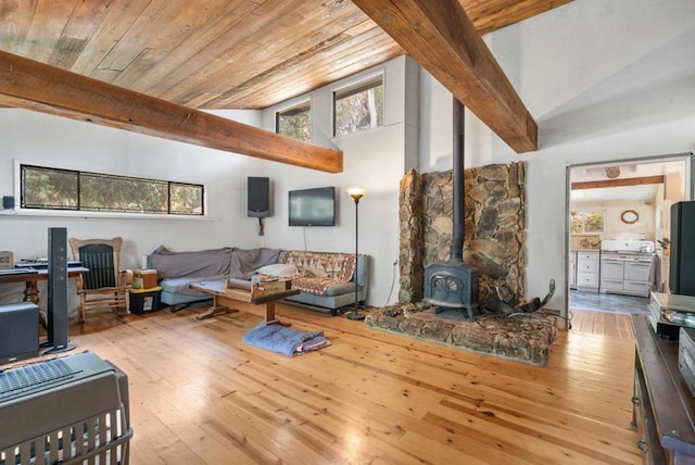 living room featuring wooden ceiling, a wood stove, light hardwood / wood-style flooring, and high vaulted ceiling