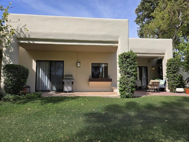 rear view of house featuring a yard and a patio