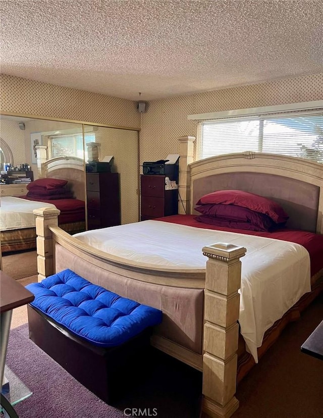 carpeted bedroom with a textured ceiling and a closet