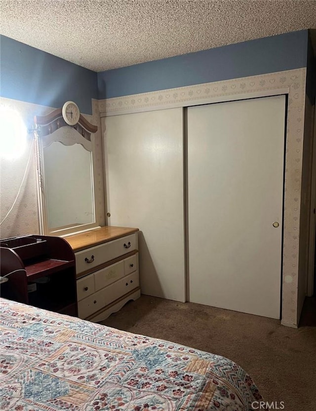 bedroom with a closet, carpet, and a textured ceiling