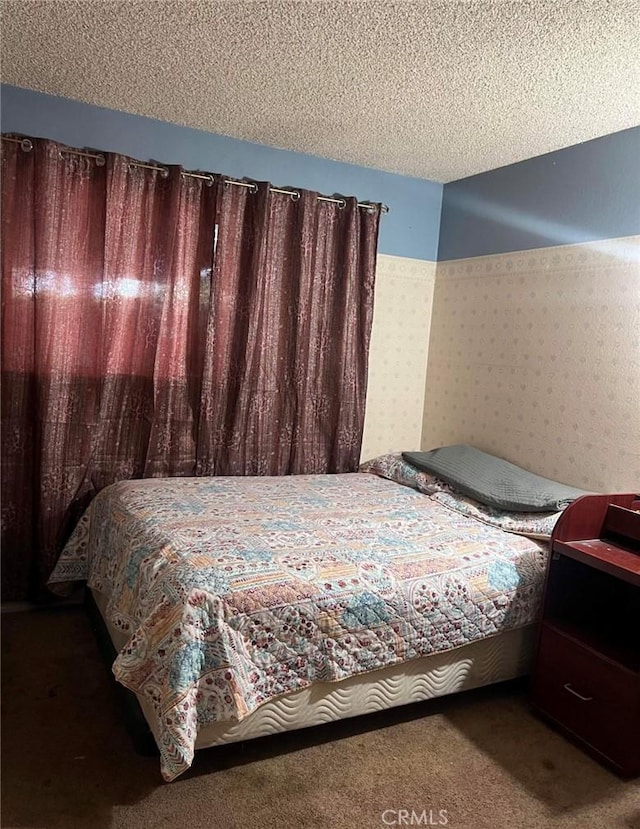 bedroom featuring carpet flooring and a textured ceiling