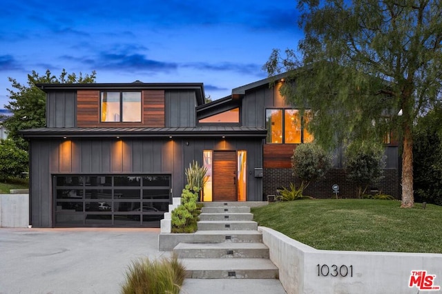 contemporary house featuring a lawn and a garage