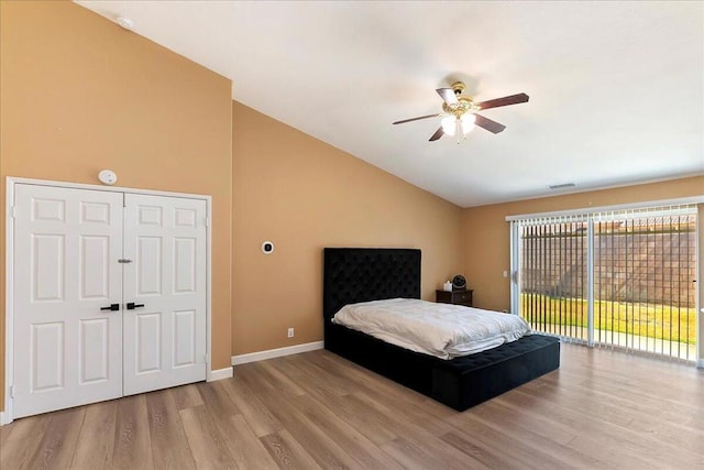 bedroom with access to exterior, light hardwood / wood-style floors, vaulted ceiling, and ceiling fan