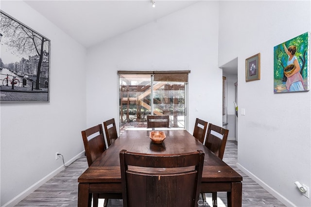 dining room featuring hardwood / wood-style floors and vaulted ceiling