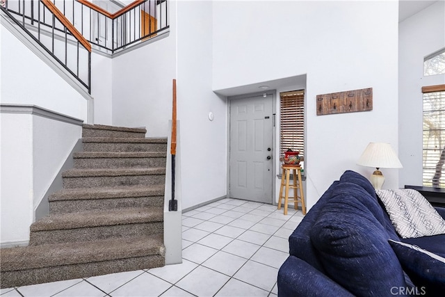 tiled foyer featuring a towering ceiling