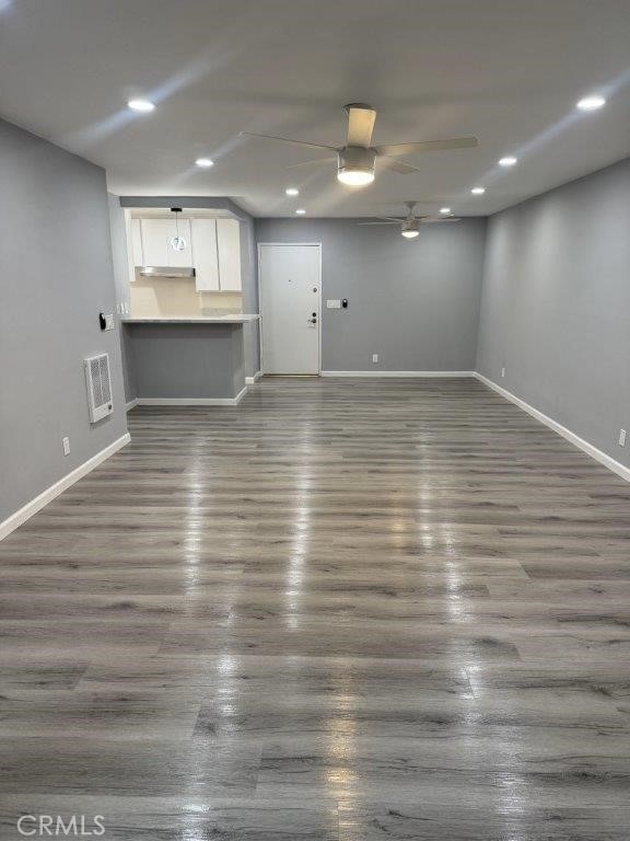 unfurnished living room with ceiling fan