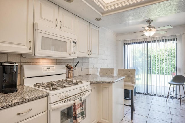 kitchen featuring white cabinets, white appliances, light stone counters, and ornamental molding