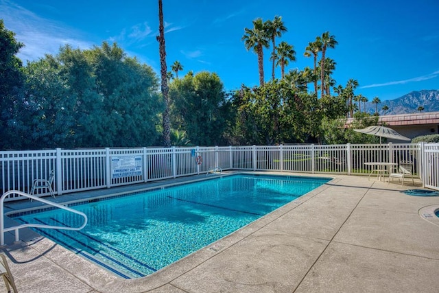 view of swimming pool with a mountain view and a patio area