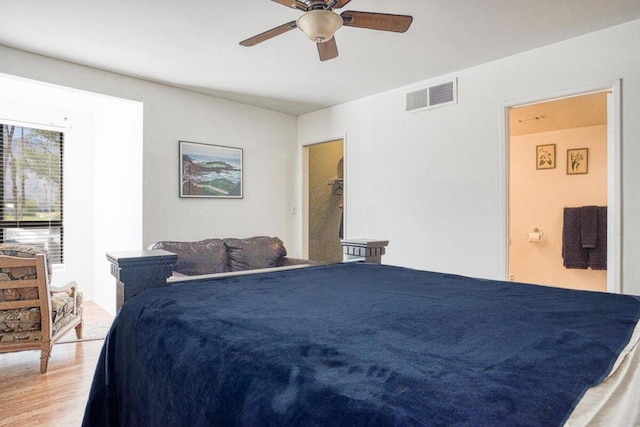 bedroom with hardwood / wood-style floors, connected bathroom, and ceiling fan