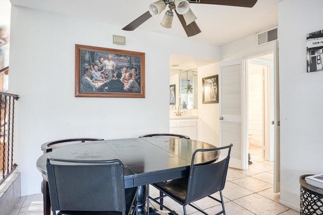 tiled dining room featuring ceiling fan and sink