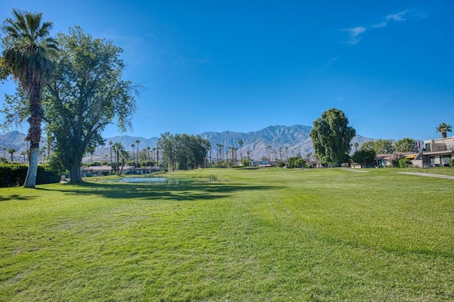 surrounding community with a mountain view and a yard