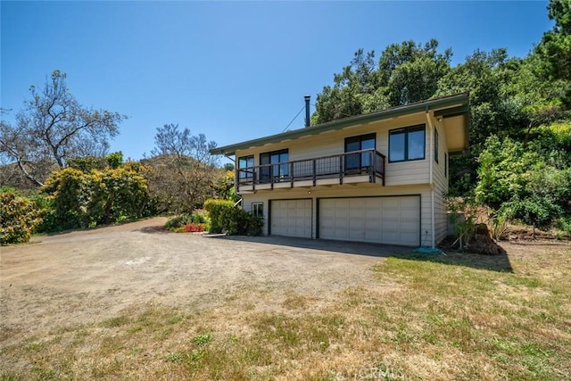 view of front of house featuring a garage and a balcony